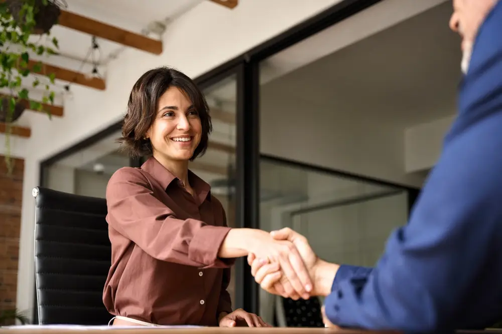 Happy,Young,Business,Woman,Bank,Manager,Handshaking,Client,At,Meeting.